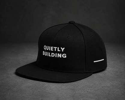 Back view of TheCapTribe Quietly Building black snapback showing Results Speak embroidery