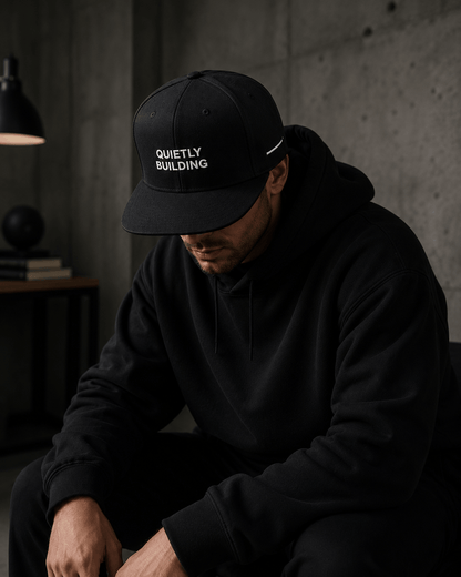 Man wearing TheCapTribe Quietly Building premium black snapback in minimalist streetwear setting