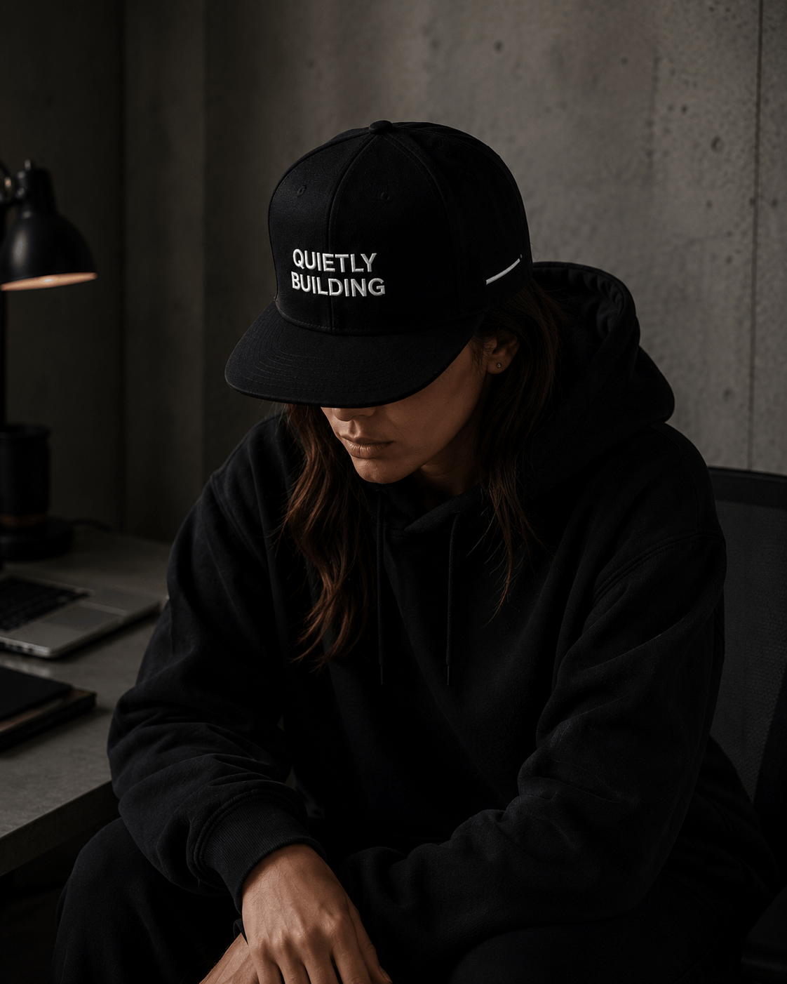 Woman wearing TheCapTribe Quietly Building premium black snapback in modern streetwear environment