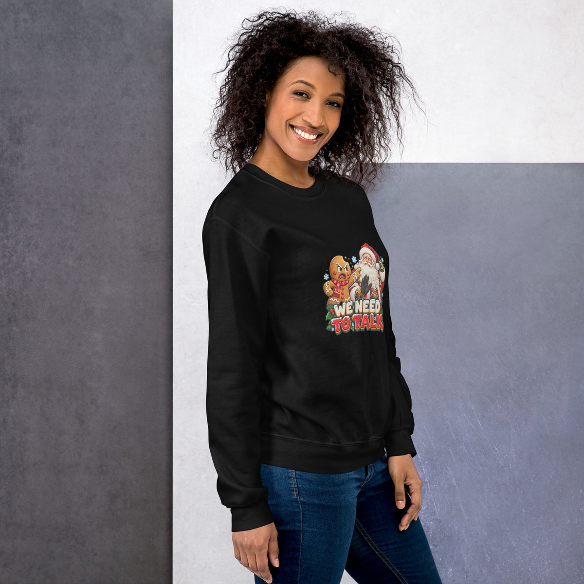 Person wearing the black unisex crewneck with the We Need to Talk Christmas design